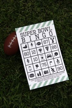 a football sitting on top of a lush green field next to a paper game board