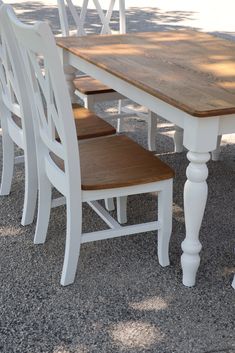 a wooden table with white chairs around it