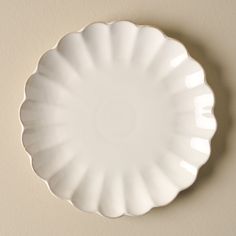 an empty white plate hanging on the wall