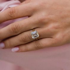 a woman's hand with a diamond ring on it