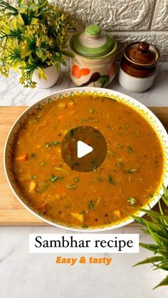 a bowl filled with soup sitting on top of a wooden cutting board next to a potted plant