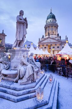 people are standing around in front of a building with many lights and statues on it