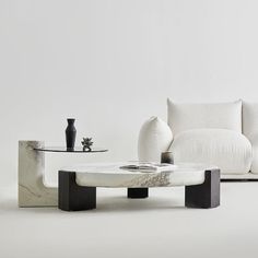 a living room with white couches and marble coffee table in front of the couch