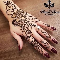 a woman's hand with henna tattoos on it