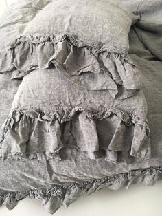 an unmade bed with ruffled linens and pillows on it's sides