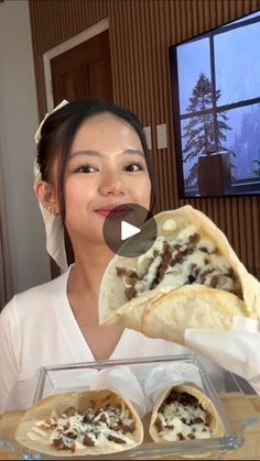 a woman is holding up some food in front of her face