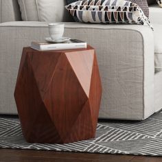 a coffee table sitting on top of a rug in front of a couch with pillows