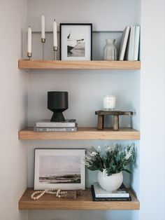 some shelves with candles and pictures on them