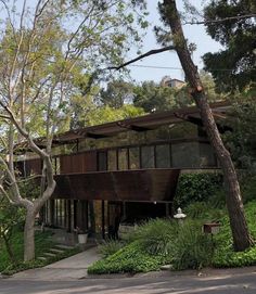 the house is surrounded by trees and bushes