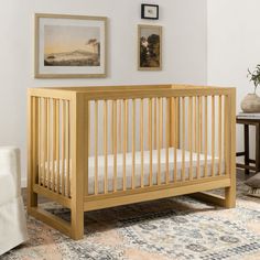 a baby crib in a room with pictures on the wall