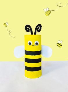 a toilet paper roll with a bee on it's head and two bees in the background