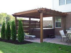 an outdoor hot tub in the middle of a yard with chairs and tables around it