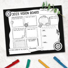 a black and white photo of a vision board surrounded by crayons on a table