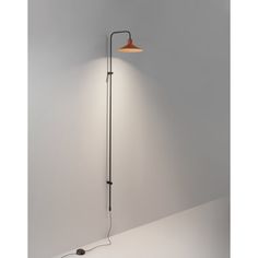 a lamp that is on the wall next to a light fixture with a cord in front of it