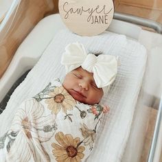 a baby is laying in a crib with a name tag on it's head