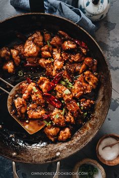 a pan filled with chicken and vegetables on top of a table