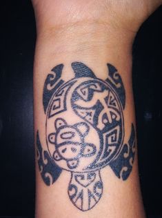 a black and white tattoo on the wrist of a person with an intricate turtle design