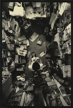 an overhead view of a woman surrounded by books and other items in a room that appears to be messy