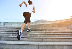 a woman running down some steps in the sun