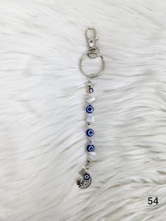 the evil eye keychain is hanging on a white fur