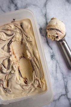 a scoop of ice cream sitting on top of a white counter next to a spoon