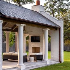 an outdoor living area with white pillars and brick walls