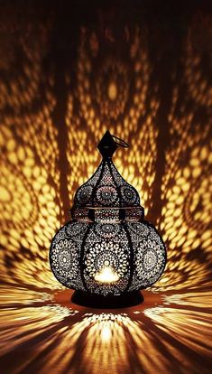 an intricately designed lantern is lit by the light coming from it's shadow