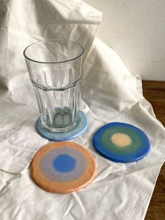 two plates and a glass on a white table cloth next to each other, one with a blue dot