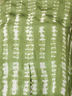 a woman wearing a green tie dyed top with white spots on it's chest