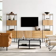 a living room filled with furniture and a flat screen tv mounted on a wall above a coffee table