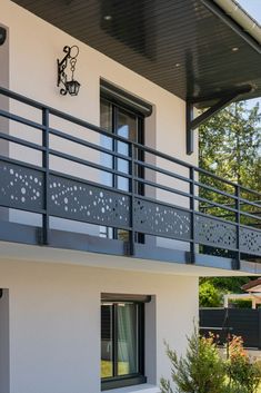 a white house with black balconies and a balcony