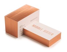 two folded business cards sitting side by side on top of each other with the word middle sister printed on them