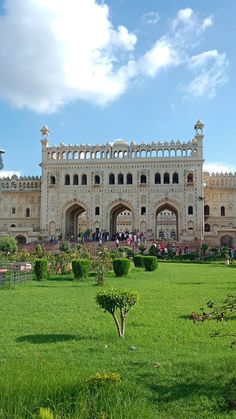 a large white building with lots of windows on it's sides and green grass in the foreground