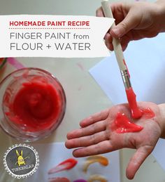 someone is painting their hands with red paint on the paper and water in front of them