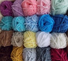 several balls of yarn are in a cardboard box with different colors and sizes on it