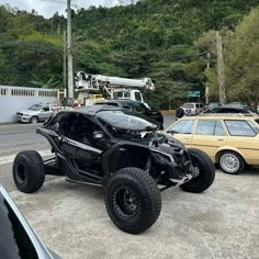 an off road vehicle parked next to a car in a parking lot with other cars