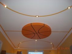 the basketball is hanging from the ceiling in the living room, and it's not too bright