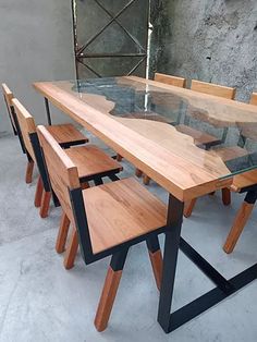 a wooden table with six chairs around it and a glass top that has been made out of wood