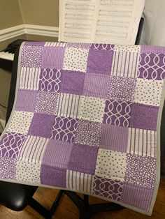 a purple and white quilt sitting on top of a chair