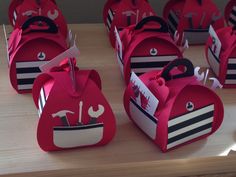 several red boxes with black and white designs on them sitting on a wooden counter top