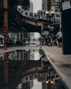 a train traveling over a bridge next to tall buildings