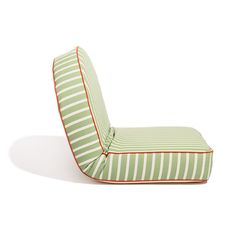 a green and white striped chair with red piping on the bottom, sitting in front of a white background