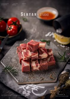 raw meat cubes on a cutting board with tomatoes and herbs around them, ready to be cut into small pieces