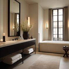 a bath room with a tub a sink and a large mirror on the wall next to a window