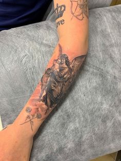 a person sitting on a couch with a tattoo on their arm and the other arm