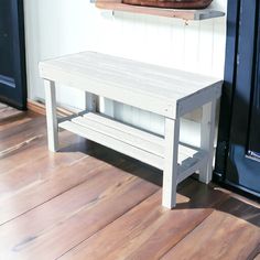 a white bench sitting on top of a hard wood floor