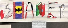 a bulletin board with drawings on it that include books, shoes and batman symbols as well as writing