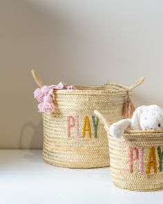 two baskets with the words play and a stuffed animal in one are sitting next to each other