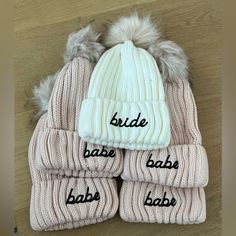 three hats and two mittens that say bride, babe, bab, baby