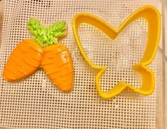 two cookie cutters shaped like carrots sitting on top of a mesh table cloth